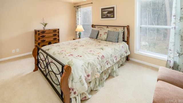 bedroom featuring light carpet and multiple windows