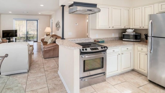 kitchen with wall chimney range hood, appliances with stainless steel finishes, light tile patterned flooring, light stone counters, and kitchen peninsula