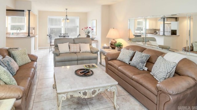 living room featuring light tile patterned floors, sink, and a chandelier