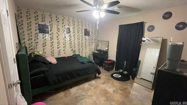 bedroom with ceiling fan and a textured ceiling