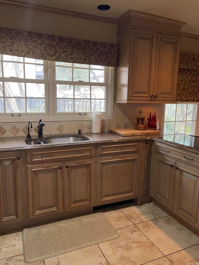 kitchen with decorative backsplash, light tile patterned floors, ornamental molding, and sink