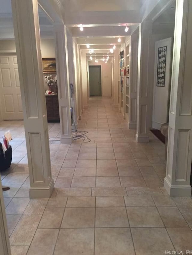 corridor with light tile patterned floors and ornate columns