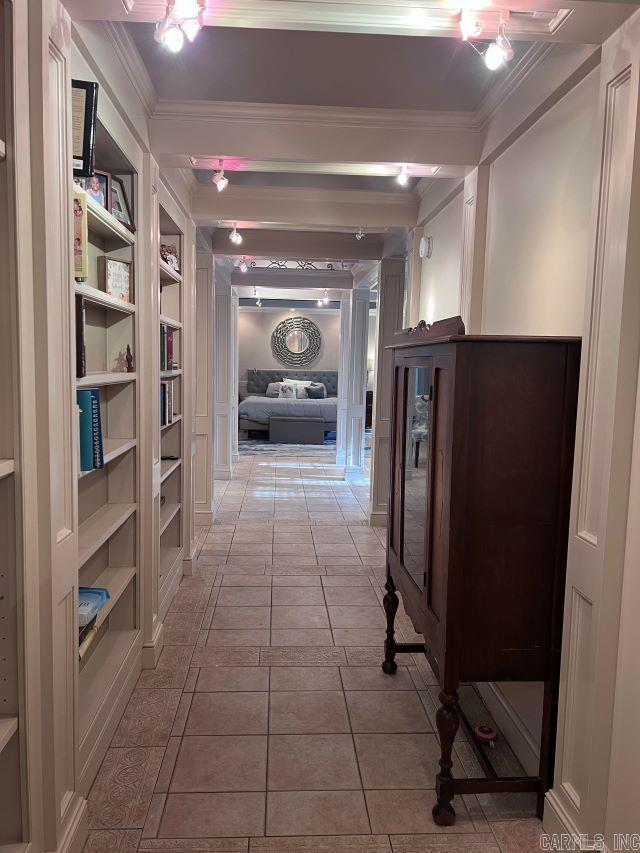 hall featuring crown molding, built in features, and light tile patterned floors