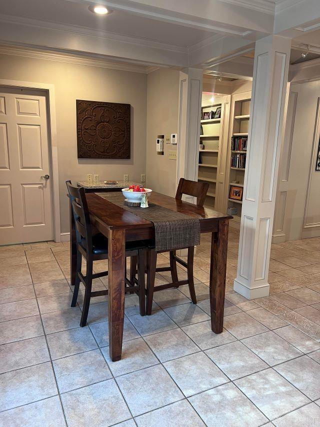 tiled dining space with built in features and ornamental molding