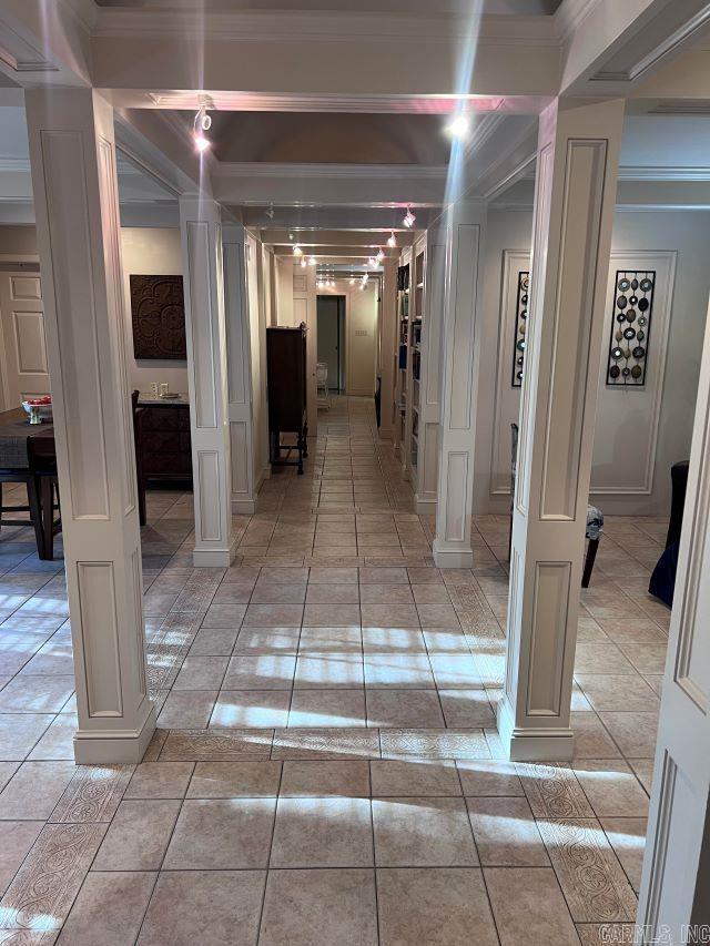 hall featuring ornamental molding and light tile patterned flooring