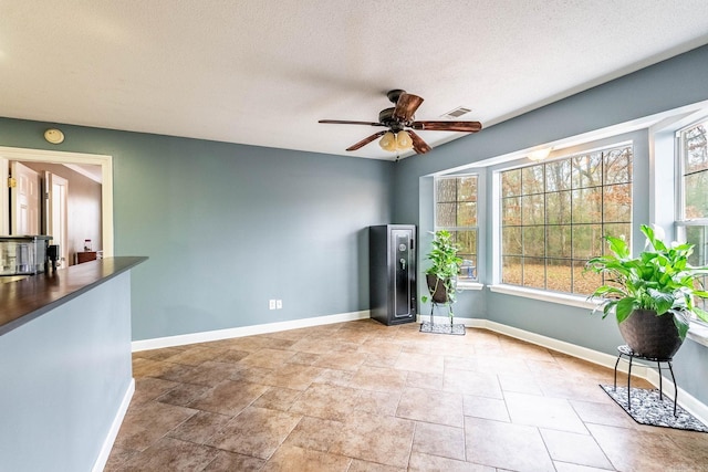 unfurnished room featuring a textured ceiling and ceiling fan