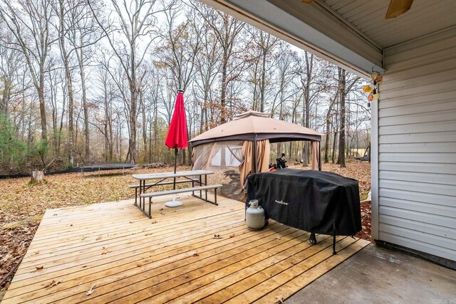 deck featuring a gazebo, grilling area, and a trampoline