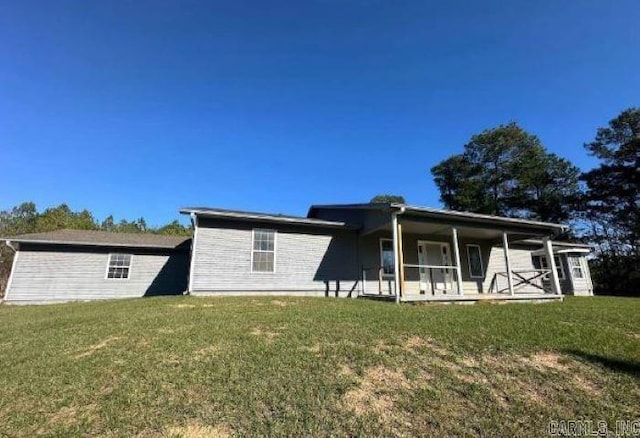 rear view of property featuring a lawn