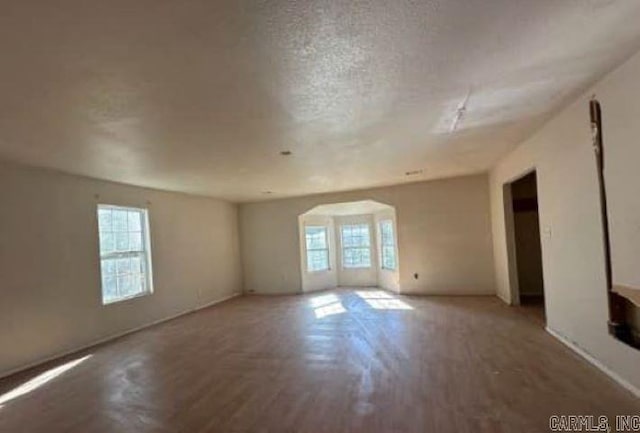 unfurnished room with a textured ceiling and hardwood / wood-style flooring