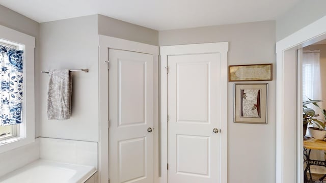 bathroom with a closet and a garden tub