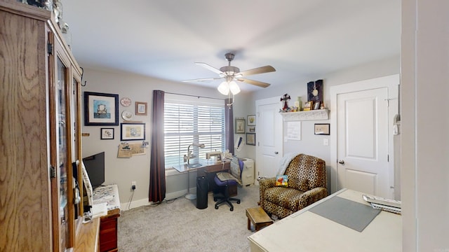 carpeted office space with baseboards and a ceiling fan