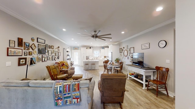 living room with crown molding, light hardwood / wood-style flooring, and ceiling fan