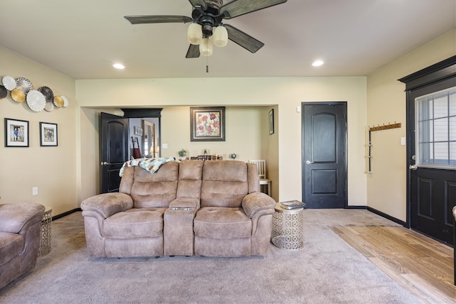 living room with ceiling fan and light hardwood / wood-style flooring