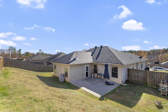 rear view of house with a patio and a lawn