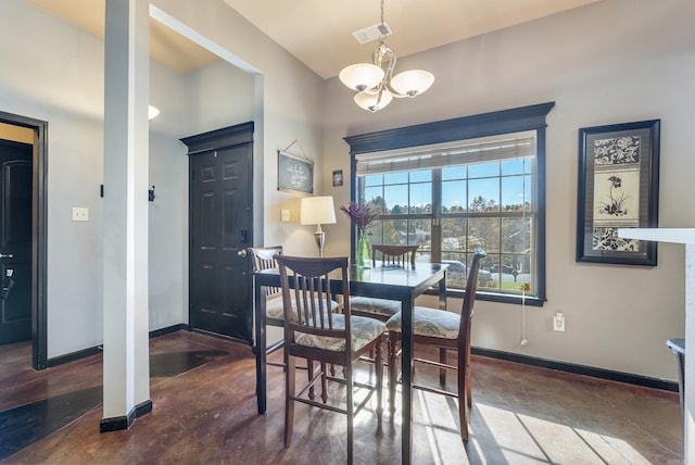 dining room featuring concrete flooring and a chandelier