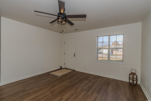 unfurnished room featuring a textured ceiling, ceiling fan, and dark wood-type flooring