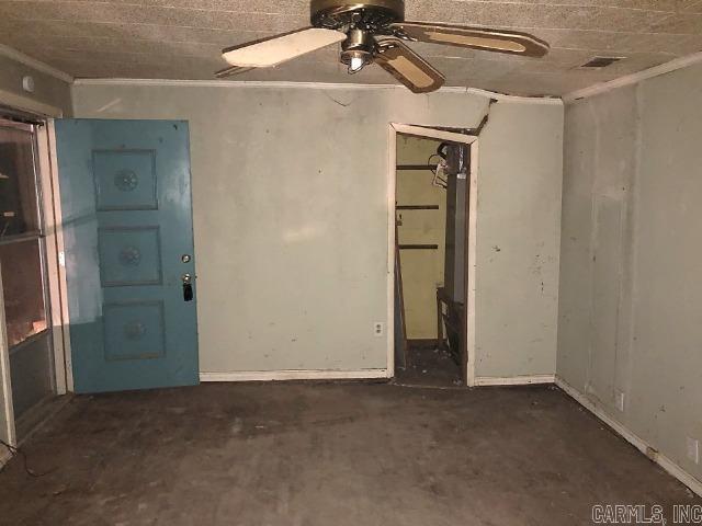 spare room featuring ceiling fan and ornamental molding