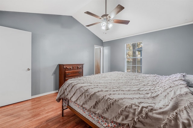 bedroom with ceiling fan, hardwood / wood-style floors, and vaulted ceiling