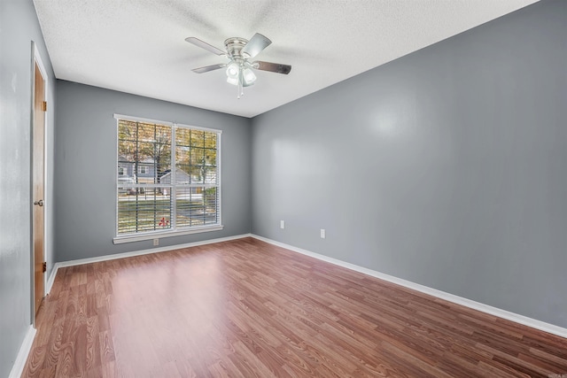 spare room featuring ceiling fan, wood-type flooring, and a textured ceiling