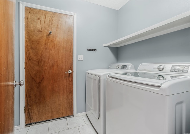 laundry area with washer and dryer and light tile patterned floors