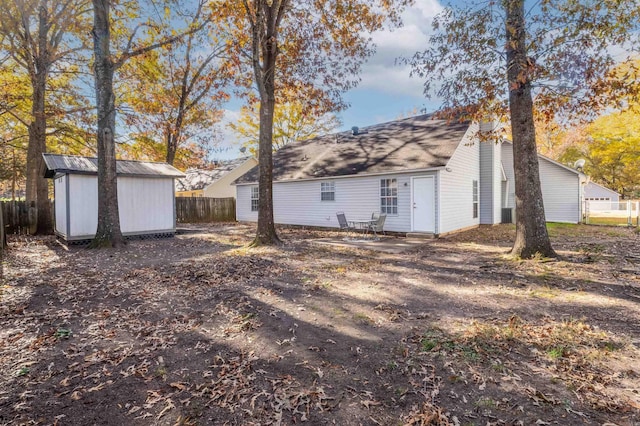 rear view of house featuring a storage shed