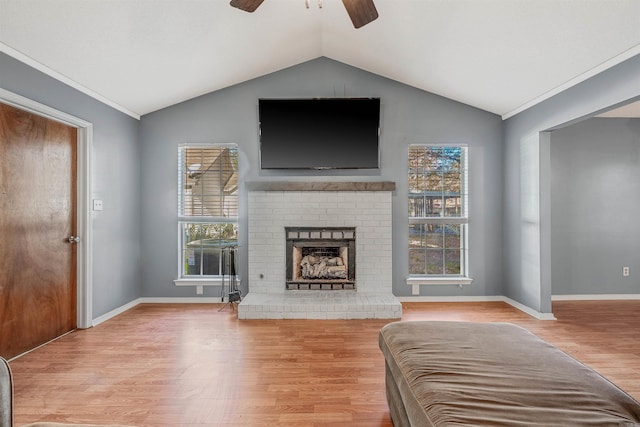 living room featuring lofted ceiling, light hardwood / wood-style flooring, and a healthy amount of sunlight