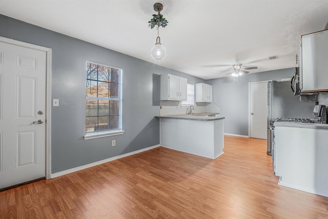 kitchen featuring kitchen peninsula, white cabinetry, ceiling fan, and light hardwood / wood-style floors