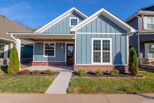 view of front of home with a porch and a front lawn