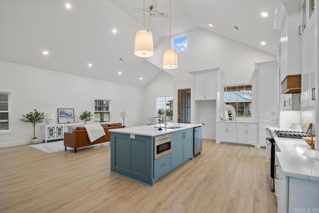 kitchen with white cabinets, high vaulted ceiling, decorative light fixtures, and appliances with stainless steel finishes