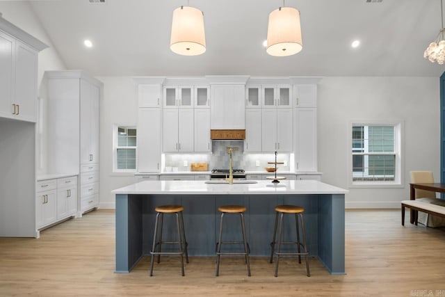 kitchen with white cabinetry, pendant lighting, and lofted ceiling