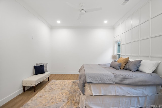 bedroom featuring ceiling fan, light hardwood / wood-style floors, and ornamental molding