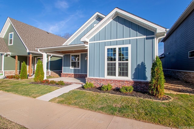 craftsman-style home with covered porch and a front lawn