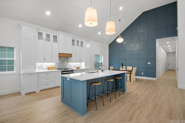 kitchen with white cabinets, high vaulted ceiling, and sink