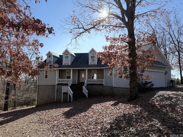 cape cod home with a garage and covered porch