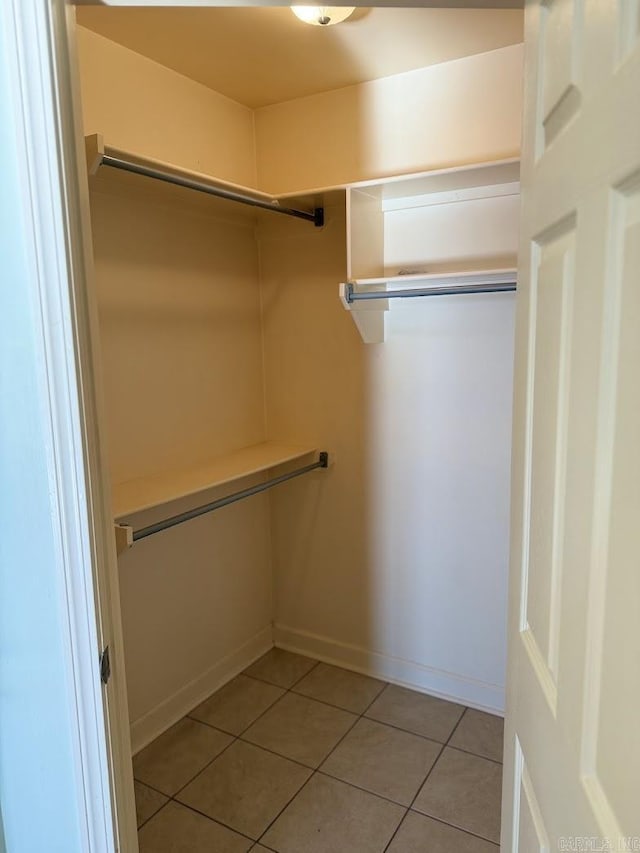 walk in closet with light tile patterned floors