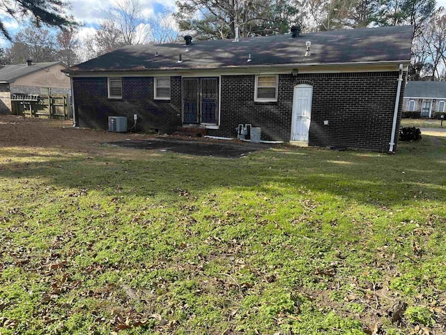 back of property featuring a lawn and cooling unit