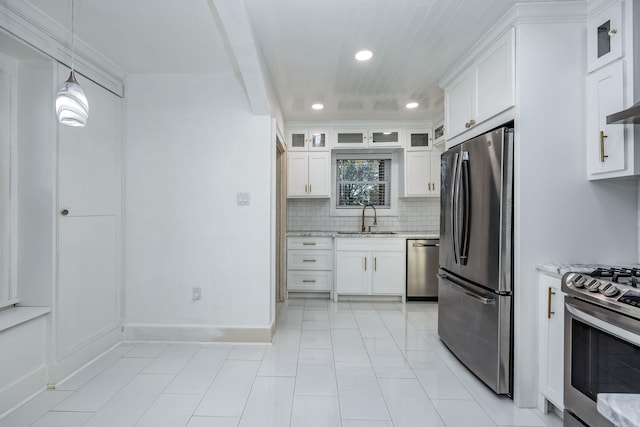 kitchen with light stone countertops, white cabinetry, sink, and stainless steel appliances