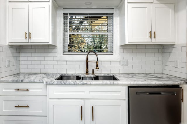 kitchen featuring stainless steel dishwasher, decorative backsplash, white cabinets, and sink