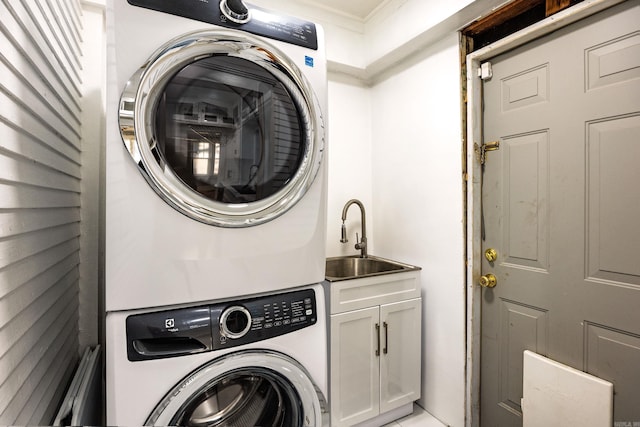 washroom with cabinets, sink, ornamental molding, and stacked washer / dryer