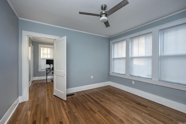 spare room featuring ceiling fan, dark hardwood / wood-style flooring, a healthy amount of sunlight, and ornamental molding