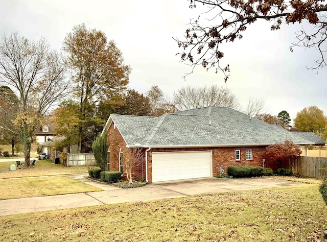 view of side of property featuring a lawn and a garage