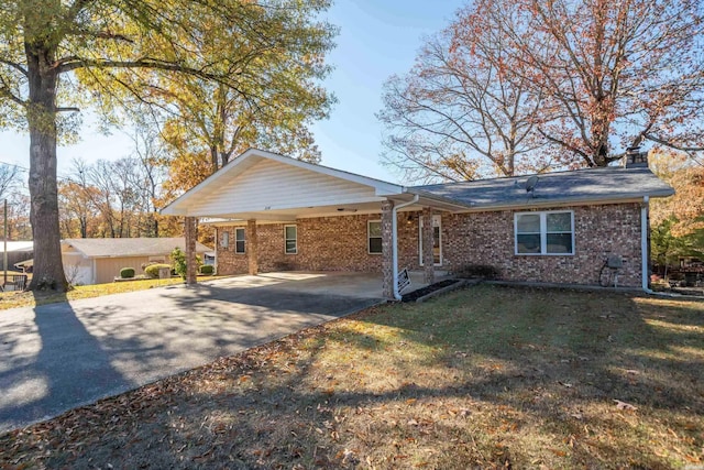 ranch-style home featuring a carport and a front yard