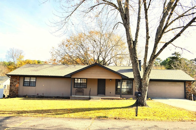 single story home with covered porch, a garage, and a front lawn