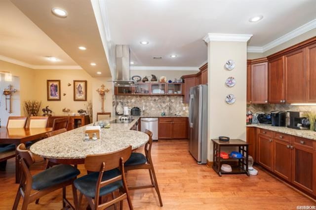 kitchen featuring crown molding, light hardwood / wood-style flooring, light stone countertops, stainless steel appliances, and extractor fan