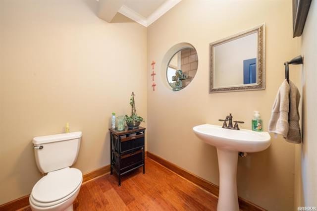 bathroom featuring hardwood / wood-style flooring, toilet, crown molding, and sink