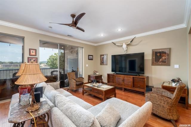 living room featuring ceiling fan, wood-type flooring, and crown molding