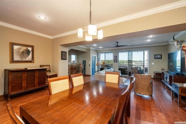 dining area with ceiling fan with notable chandelier, wood-type flooring, and ornamental molding