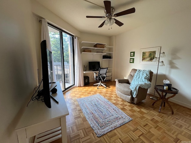 sitting room with ceiling fan and light parquet floors