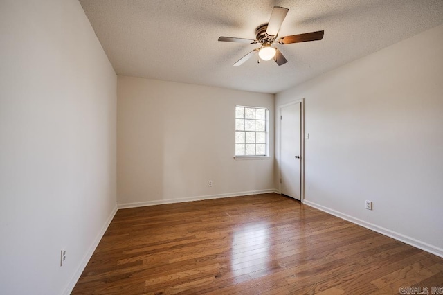 empty room with ceiling fan, dark wood-type flooring, and a textured ceiling