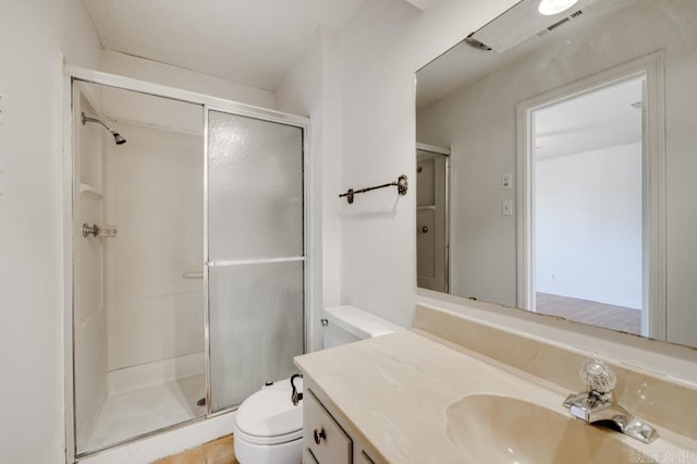 bathroom with tile patterned flooring, vanity, toilet, and a shower with shower door